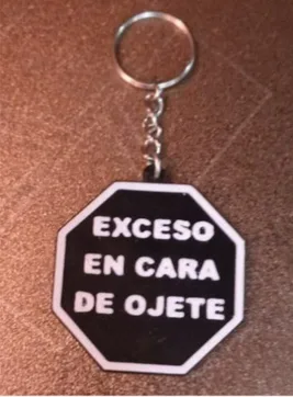 Llavero octogonal negro con una frase en letras blancas